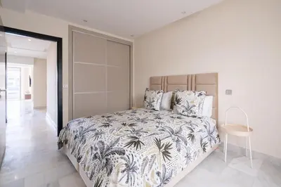 a bedroom with a large bed and a table at Le yacht palace beachfront residence 2 BR 2 BA in Casablanca