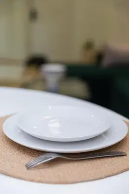 a white plate and a fork on a table at 2BR Apartment in Prestigious Mahaj Riad by MERAT HOME in Rabat