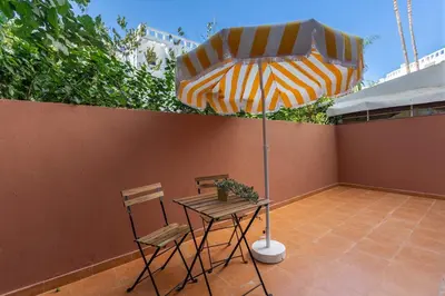 a table and chairs and an umbrella on a patio at 2BR Apartment in Prestigious Mahaj Riad by MERAT HOME in Rabat