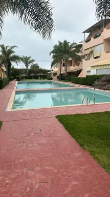 a swimming pool in front of a building at Rayan beach Residence avec picine a tamaris in Tamaris