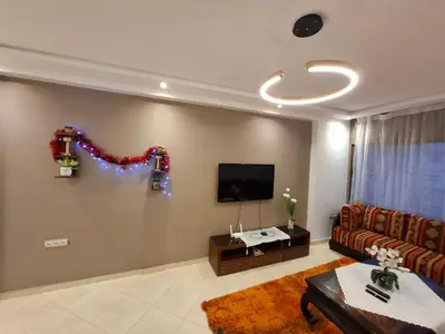 a living room with a couch and a flat screen tv at Apt 3 ch Casablanca 3 min Casa Voyageurs idéal pour une famille in Casablanca