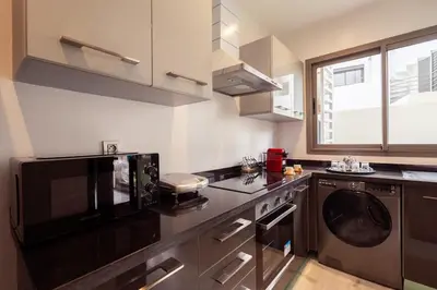 a kitchen with a microwave and a dishwasher at Le yacht luxury apartment 2BR 2BA corniche with parking in Casablanca