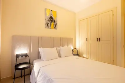 a bedroom with a white bed and a chair at Luxury 2 BR 2 BA Alsace Lorraine downtown in Casablanca