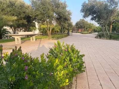 a park with a bench and some flowers and trees at cozy living, Chic 3BR appartement with parking! in Casablanca