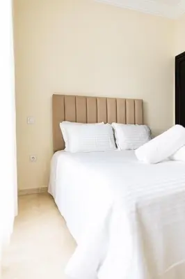 two beds in a bedroom with white sheets at cozy living, Chic 3BR appartement with parking! in Casablanca