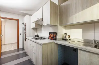 a kitchen with white cabinets and a stove top oven at 3BR Modern Stay in Heart of Rabat in Rabat