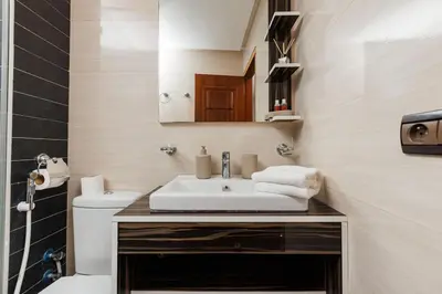 a bathroom with a sink and a toilet and a mirror at 3BR Modern Stay in Heart of Rabat in Rabat