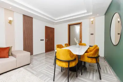 a dining room with a white table and yellow chairs at 3BR Modern Stay in Heart of Rabat in Rabat