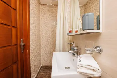 a bathroom with a white sink and a shower at 3BR Modern Stay in Heart of Rabat in Rabat