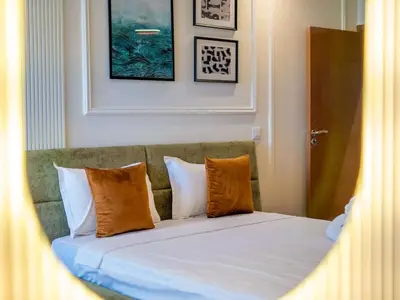 a bed with orange and white pillows in a room at Modern & Central 2BR Stay in Rabat in Rabat