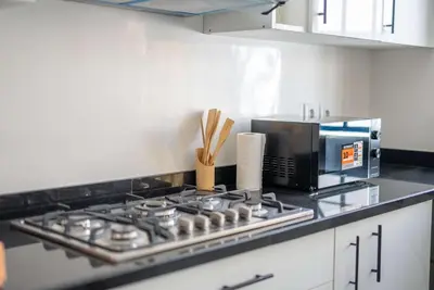 a stove top oven in a kitchen with a microwave at Modern & Central 2BR Stay in Rabat in Rabat