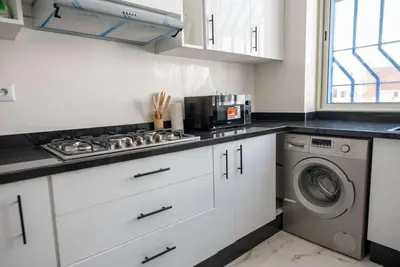 a kitchen with a stove and a washing machine at Modern & Central 2BR Stay in Rabat in Rabat