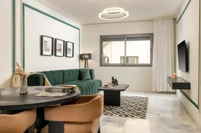 a living room with a green couch and a table at The Loft Residence by GoodMove - Maarif Casablanca in Casablanca