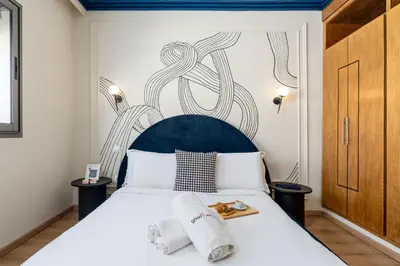 a bedroom with a white bed with a blue headboard at The Loft Residence by GoodMove - Maarif Casablanca in Casablanca