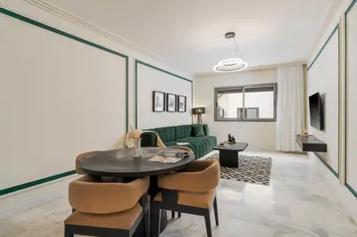 a living room with a green couch and a table at The Loft Residence by GoodMove - Maarif Casablanca in Casablanca
