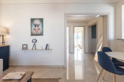 a living room with a table and blue chairs at Luxury 2BR Apartment City Center with Parking in Casablanca