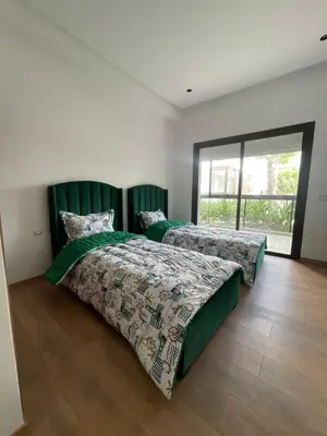 a bedroom with two beds and a large window at Appartement Luxe Vue Piscine Résidence Les Perles de Bentriaa, El Mansouria in Mohammedia