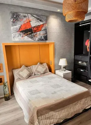 a bedroom with a bed and a painting on the wall at Le mataki in Mohammedia