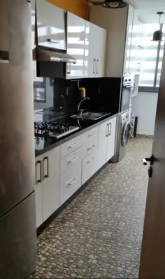 a kitchen with white cabinets and a stove top oven at Le mataki in Mohammedia