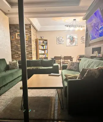 a living room with green couches and a table at Le mataki in Mohammedia