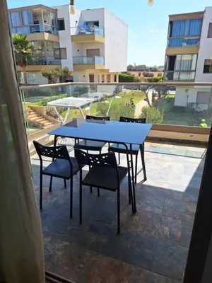 a table and chairs on the balcony of a building at Blue beach in Sidi Rahal