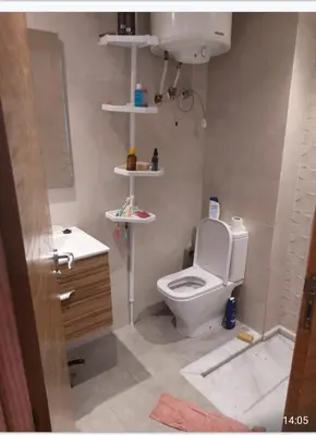 a bathroom with a white toilet and a sink at Blue beach in Sidi Rahal