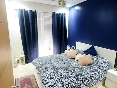 a bedroom with blue walls and a bed with pillows at Buznika marocco in Bouznika