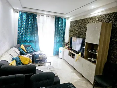 a living room with a couch and a television at Buznika marocco in Bouznika