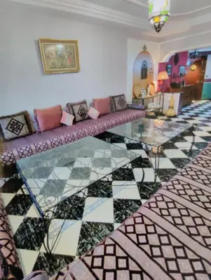 a living room with a couch and a glass table at Spacious with Great Location in Casablanca