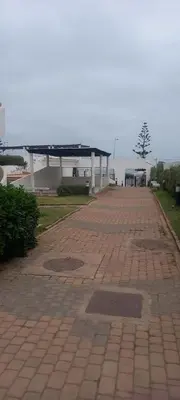 a brick walkway with a building in the background at Vue Mer & Sérénité, Appartement Chic avec Piscine à Dar Bouazza in Tamaris