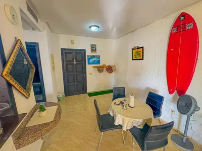a dining room with a table and surfboards on the wall at DarBouazza SurfHouse Sea View in Tamaris