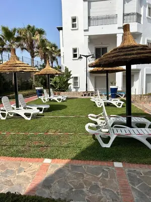 a group of lawn chairs and umbrellas in a yard at DarBouazza SurfHouse Sea View in Tamaris