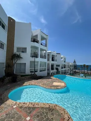 a building with a swimming pool in front of a building at DarBouazza SurfHouse Sea View in Tamaris