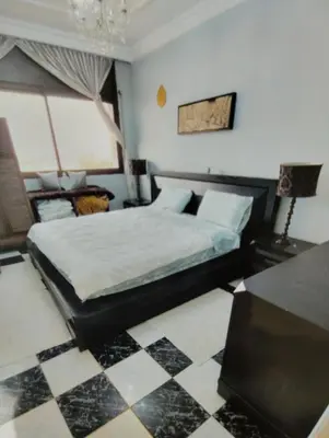 a bedroom with a bed and a checkered floor at Rosy Bliss in Casablanca