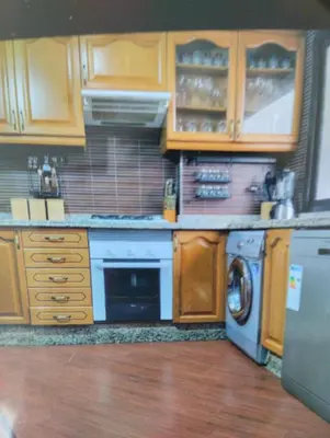 a kitchen with wooden cabinets and a washer and dryer at Rosy Bliss in Casablanca