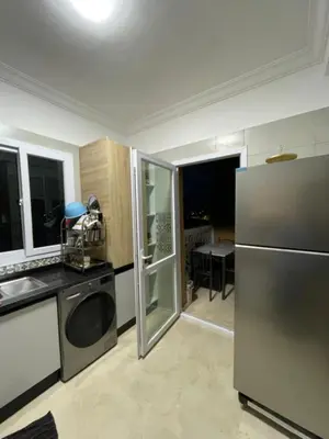 a kitchen with a stainless steel refrigerator and a table at ossama in Mansouria