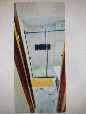 a bathroom with a shower with a glass door at ossama in Mansouria