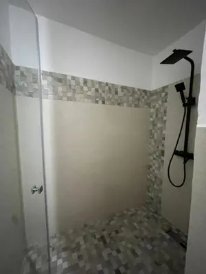a shower with a glass door in a bathroom at ossama in Mansouria