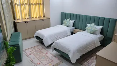 a bedroom with two beds and a green headboard at Studio Tetouan in Deroua