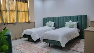 a bedroom with two beds and a green headboard at Studio Tetouan in Deroua