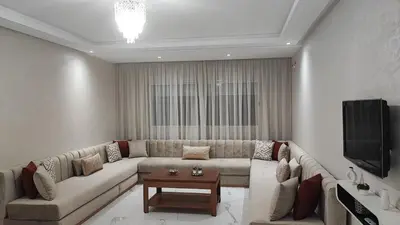 a living room with a couch and a tv at Appartement familial vue piscine in Temara