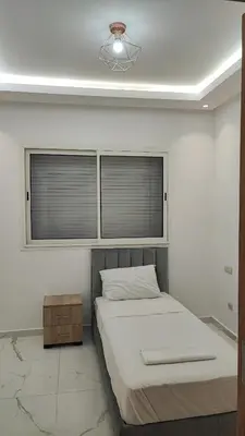 a bedroom with a bed and a window at Appartement familial vue piscine in Temara