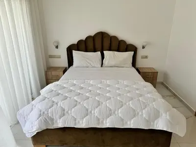 a bedroom with a large bed with a white comforter at Appartement familial vue piscine in Temara