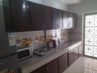 a kitchen with brown cabinets and a counter top at Relaxation stay in Casablanca
