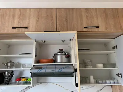 a kitchen with a cupboard with a pot at Cozy modern apartment 3 min drive beach access in Sidi Rahal