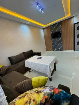 a living room with a couch and a table at Cozy modern apartment 3 min drive beach access in Sidi Rahal