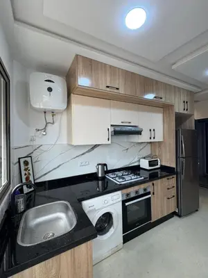 a kitchen with a sink and a stove and a dishwasher at Cozy modern apartment 3 min drive beach access in Sidi Rahal