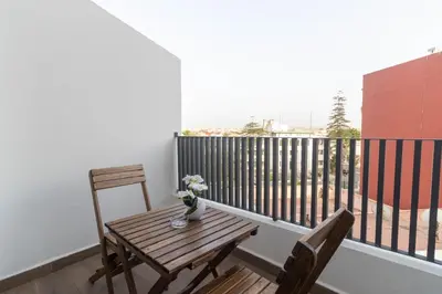 a small balcony with a wooden table and chairs at Small nest in a good location, quiet in Casablanca