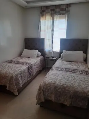 a bedroom with two beds and a window at Séjour Idéal à Tamaris Appartement Meublé Tout Confort in Tamaris
