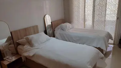 a bedroom with two beds and a window at Résidence balnéaire casablanca in Dar el Maïzi